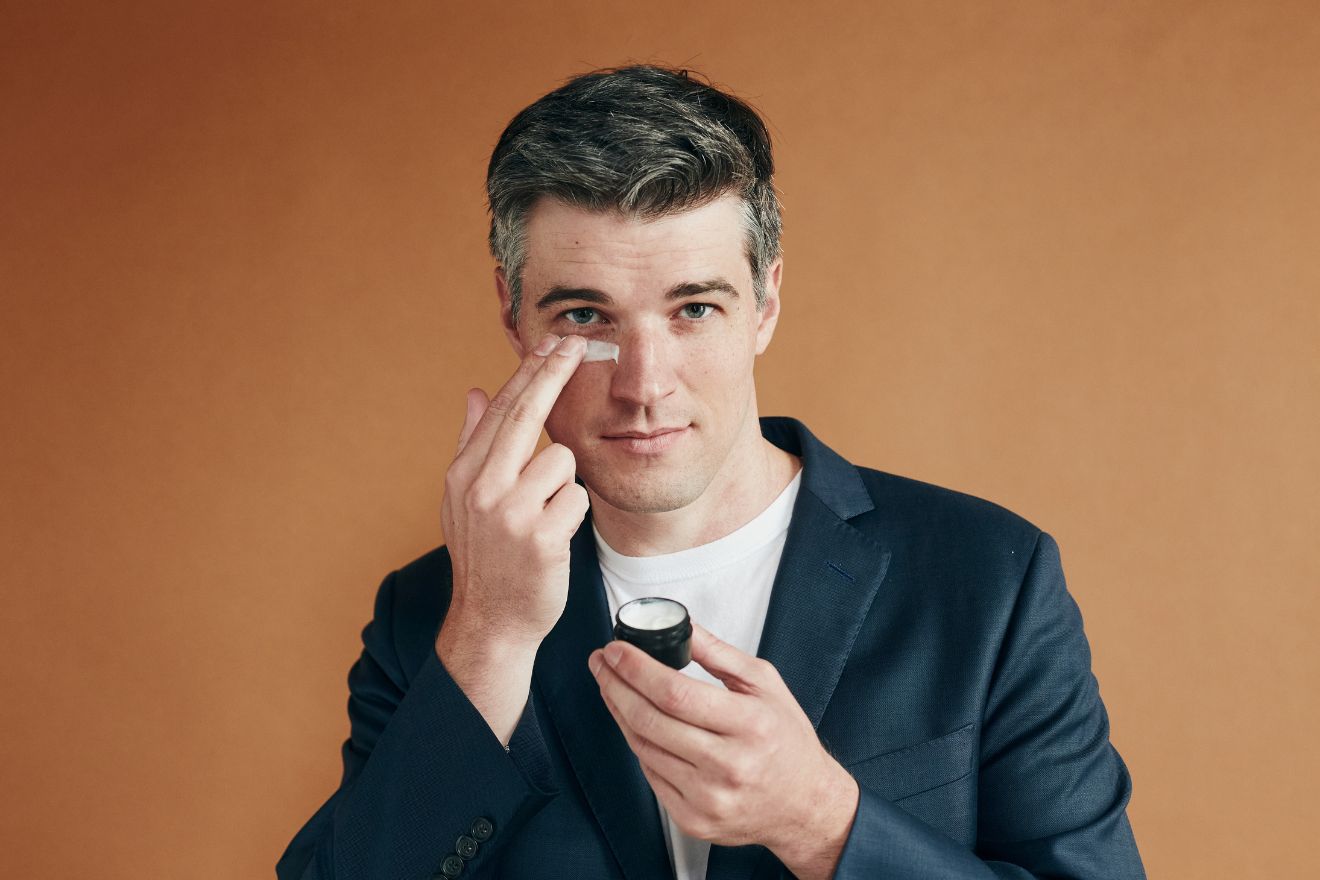 Man applying eye cream to face