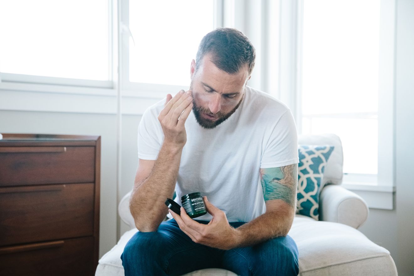 Man applying skincare product to face