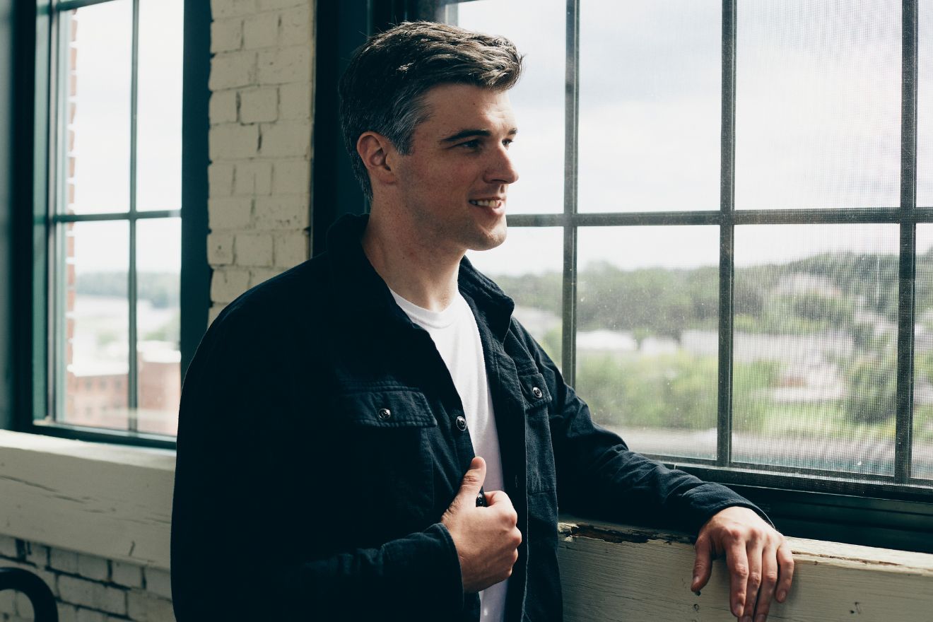 Man standing next to window