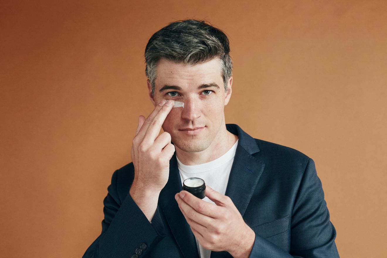 man applying eye cream to face