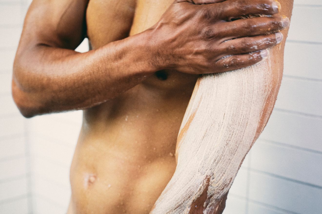 Man applying body scrub to arm