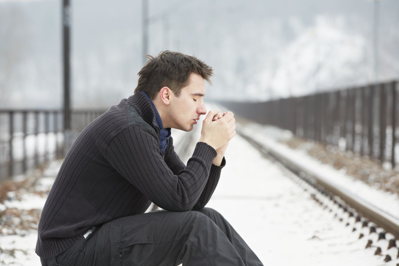 Man sitting on bench in snow